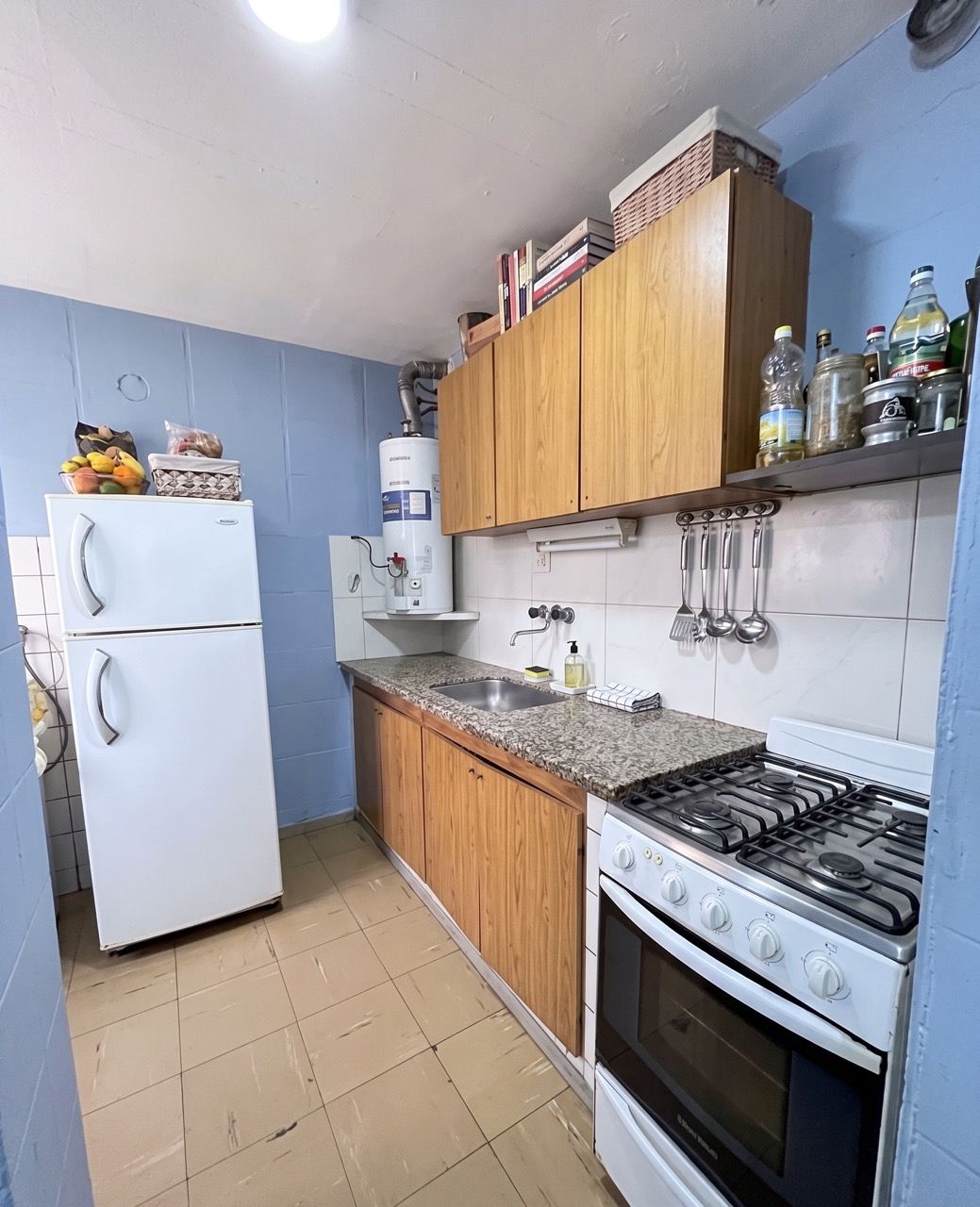 Cocina con mesada de granito, alacenas y cocina a gas