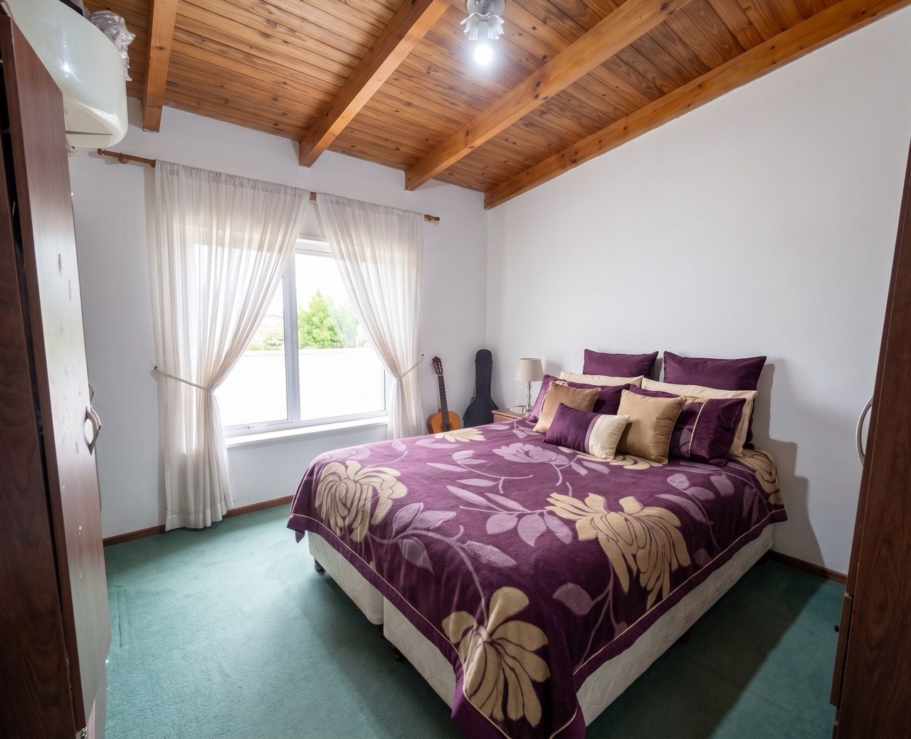 Dormitorio con techo de madera y cama matrimonial